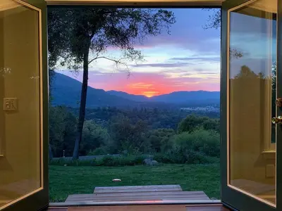 a view of a sunset through a glass door at Sunset Cottage near Yosemite in Oakhurst