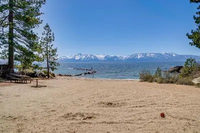 a sandy beach with a view of the water and mountains at Beach and Skiing at Zephyr Cove house in Zephyr Cove