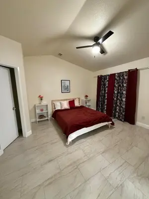 a bedroom with a bed and a ceiling fan at Vineyard inspired house in stockton in Stockton