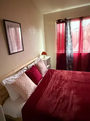 a bedroom with a bed with red curtains at Vineyard inspired house in stockton in Stockton