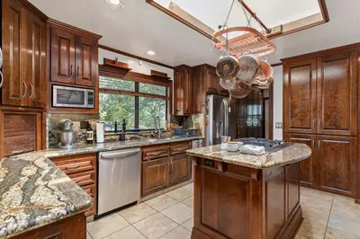 a kitchen with wooden cabinets and stainless steel appliances at Cozy Lake View 4Bd 2,5Br Retreat in 5 Acres, Hot Tub and more in Auburn