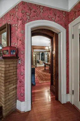an open doorway to a room with red wallpaper at The Spalding House Comfort in Visalia home in Visalia
