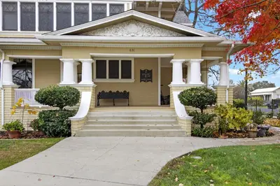 a yellow house with a bench on the front porch at The Spalding House Comfort in Visalia home in Visalia