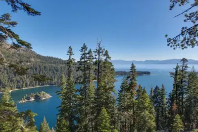 a view of a lake through the trees at Lakeview Luxury Getaway in South Lake Tahoe