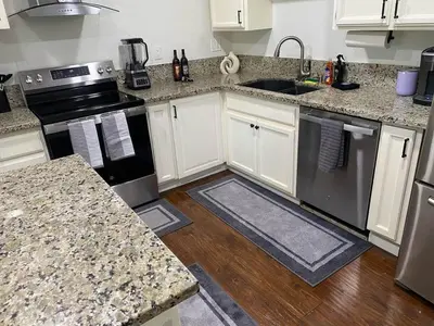 a kitchen with white cabinets and black appliances at Kipps Hill Haven A - Folsom Lake Escape in El Dorado Hills