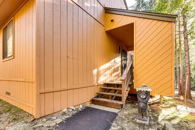 a yellow house with a staircase leading to a fire hydrant at Community Perks and Watercrafts Shaver Lake Condo in Shaver Lake