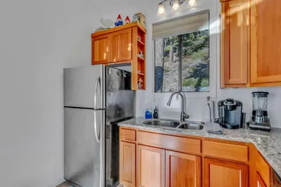 a kitchen with a stainless steel refrigerator and wooden cabinets at Incline Village Views - Pellet Stove Deck in Incline Village