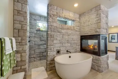 a bathroom with a bath tub and a fireplace at Steps From Sledding Hill! Soda Springs Mtn Retreat in Soda Springs