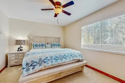 a bedroom with a bed and a ceiling fan at Lakeside Ski House in Carnelian Bay