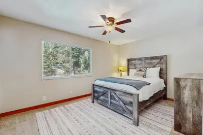 a bedroom with a bed and a ceiling fan at Lakeside Ski House in Carnelian Bay