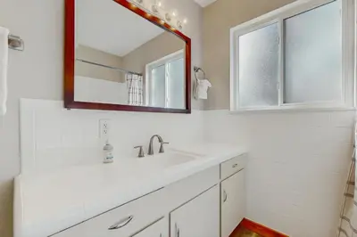 a white bathroom with a sink and a mirror at Lakeside Ski House in Carnelian Bay