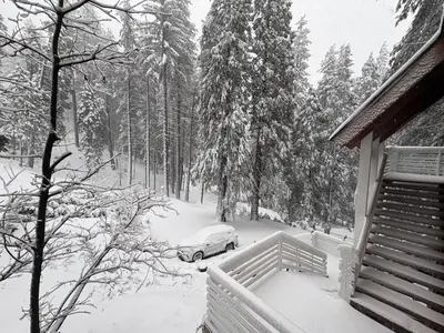 a car parked in the snow next to a house at El Capitan Hideaway - A-Frame Cabin Yosemite West in Yosemite West