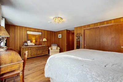 a bedroom with wooden walls and a bed and a mirror at Cabin on the Green in South Lake Tahoe