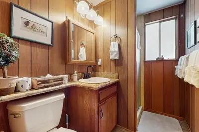 a bathroom with a toilet and a sink and a mirror at Cabin on the Green in South Lake Tahoe