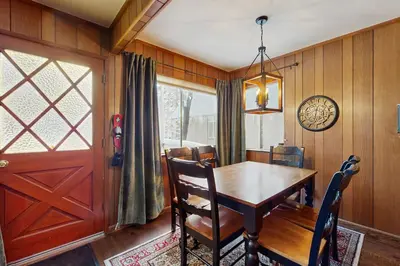 a dining room with a wooden table and a door at Cabin on the Green in South Lake Tahoe