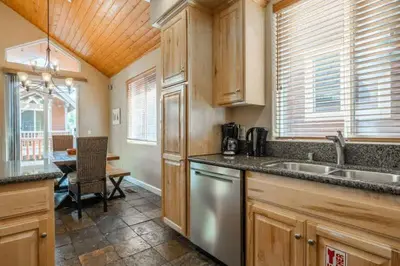 a kitchen with wooden cabinets and a dining table at Mammoth Gateway Village #3 in Mammoth Lakes