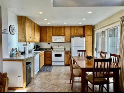 a kitchen with wooden cabinets and a table with chairs at Sierra Park Villas 28 in Mammoth Lakes
