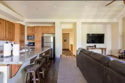 a living room with a couch and a kitchen at Lodges 1123 in Mammoth Lakes