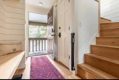 a hallway with a door and stairs with a rug at Seasons Four 152 in Mammoth Lakes