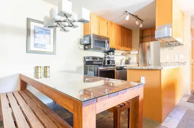 a large kitchen with a wooden island in the middle at San Sierra 24 in Mammoth Lakes