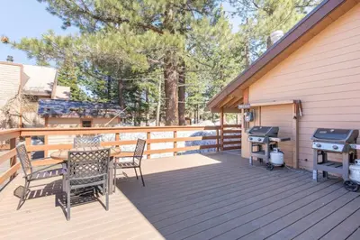 a deck with a table and chairs and a grill at San Sierra 24 in Mammoth Lakes