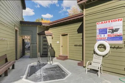 a building with a pool and a chair on a patio at Mammoth Sierra Townhome 1 in Mammoth Lakes