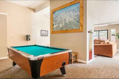 a living room with a pool table in it at Mammoth Ski and Racquet 116 in Mammoth Lakes