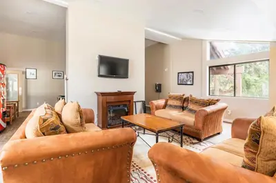 a living room with leather furniture and a tv at Mammoth Ski and Racquet 116 in Mammoth Lakes