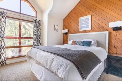 a bedroom with a large bed and a window at Aspen Creek 230 in Mammoth Lakes