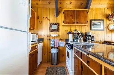 a kitchen with wooden cabinets and a white refrigerator at Mammoth View Villas 39 in Mammoth Lakes