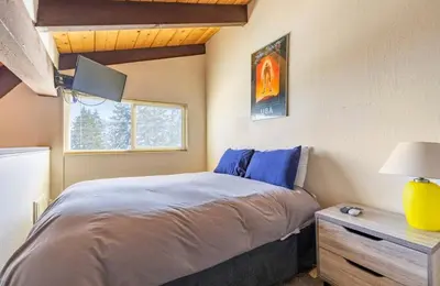 a bedroom with a bed and a desk and a window at Mammoth View Villas 39 in Mammoth Lakes