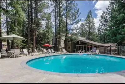 a swimming pool with chairs and a house at Viewpoint 151 in Mammoth Lakes