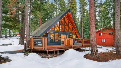 a cabin in the woods in the snow at Hot Tub • Firepit • Loft Suite Mins to World-Class Skiing Tahoe A-Frame Retreat by AvantStay in Carnelian Bay