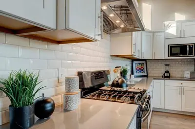 a kitchen with white cabinets and a stove top oven at Stunning View! UNR-Groups-Deck-Reno-Minerva House in Reno