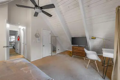 a bedroom with a ceiling fan and a bed and a desk at Zephyr Chalet Steps from Zephyr Cove in Glenbrook