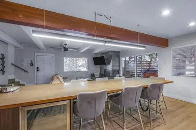 a kitchen with a large wooden bar with chairs at Zephyr Chalet Steps from Zephyr Cove in Glenbrook