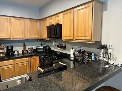 a kitchen with wooden cabinets and a stove top oven at Ski-in Ski-out Family Condo steps from lifts in Kirkwood