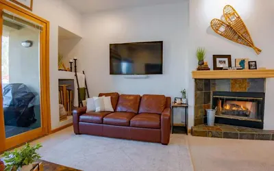a living room with a leather couch and a fireplace at Ski-in Ski-out Family Condo steps from lifts in Kirkwood