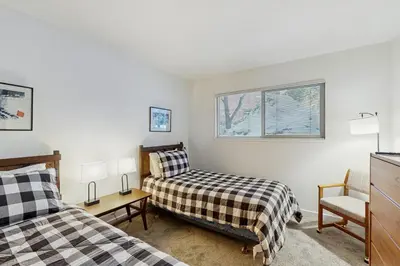 a small bedroom with two beds and a chair at Vintage Tahoe Chic at Incline Village in Incline Village