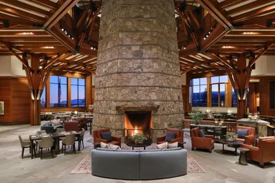 a lobby with a stone fireplace and tables and chairs at Ritz-Carlton Northstar Luxury Ski-In Ski-Out in Truckee