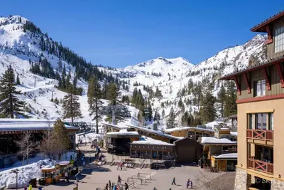 a ski resort with snow covered mountains in the background at 3BR Condo in Village at Palisades - Premier in Olympic Valley