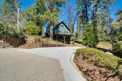 a house on a hill with a driveway at The Green Hideaway Arnold Cabin in the Pines! in Arnold