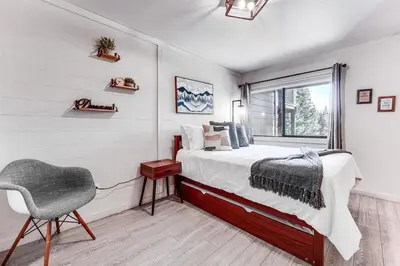 a bedroom with a bed and a chair and a window at Northstar Nest in Truckee