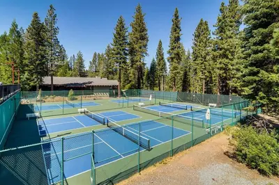 a couple of tennis courts with trees in the background at Northstar Nest in Truckee
