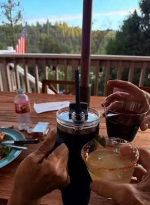 a person sitting at a table with a drink at StayCation Sierra – Nonpareil Retreat in Groveland