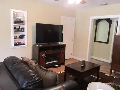 a living room with a couch and a flat screen tv at Beautiful house by the river and the villager in Fair Oaks