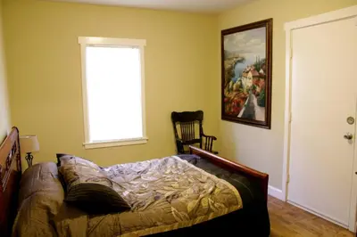 a bedroom with a bed and a window and a chair at Beautiful house by the river and the villager in Fair Oaks