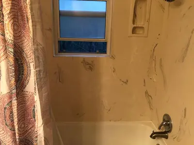 a bathroom with a bath tub and a window at The village Inn in Fair Oaks