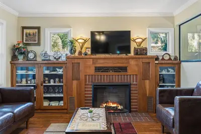 a living room with a fireplace and a flat screen tv at The village Inn in Fair Oaks