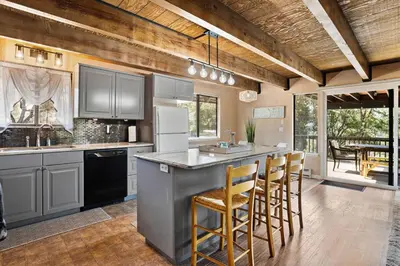 a kitchen with a large island with bar stools at Peaceful Pines Escape Near Yosemite, Lake & Golf in Groveland